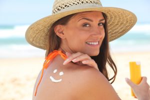 Woman applying suncream at the beach